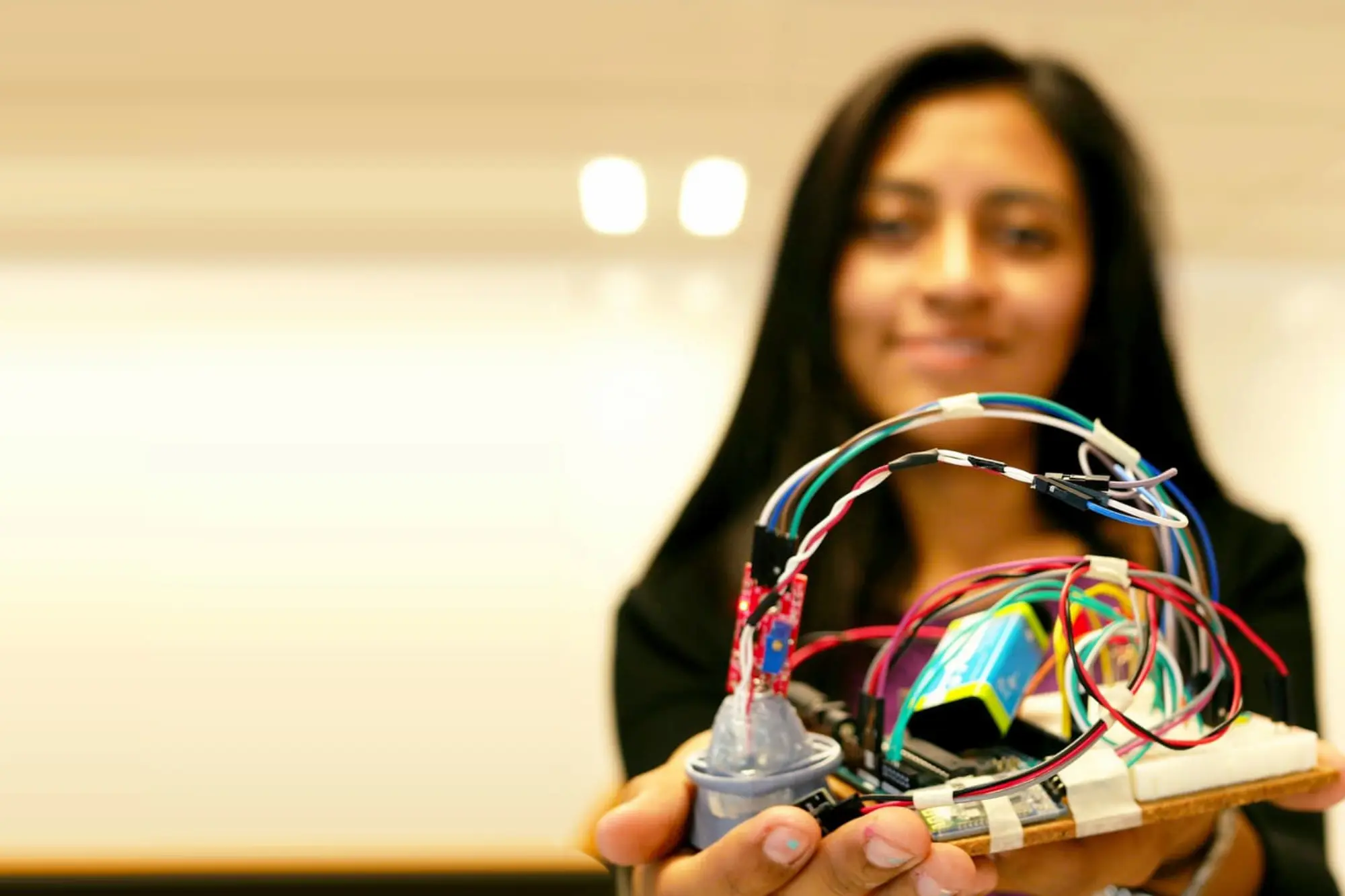 Emprendedora mostrando la placa de circuitos de un prototipo version alfa